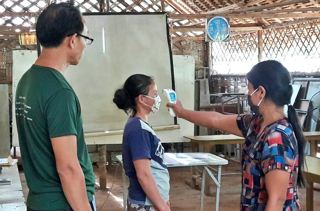 Head teacher training on how to use infrared thermometer and mask for Covid-19 prevention to prepare for school re-opening and pilot class in Ban Mai Nai Soi temporary shelter on 28 May 2020. (JRS AP)